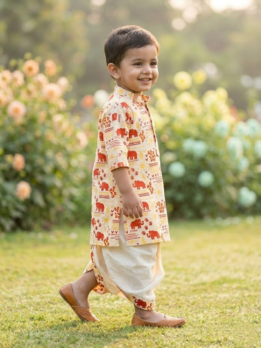 Child wearing a Dhoti Kurta with elephant patterns in a garden setting